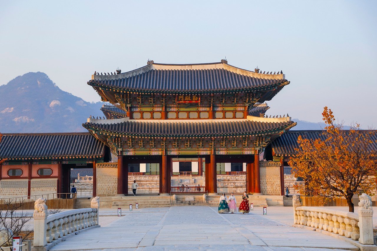 Vue de l'extérieur d'un palais à Séoul, avec son architecture traditionnelle coréenne, ses toits incurvés et ses éléments décoratifs complexes, offrant un aperçu de l'histoire et de la culture de la Corée du Sud