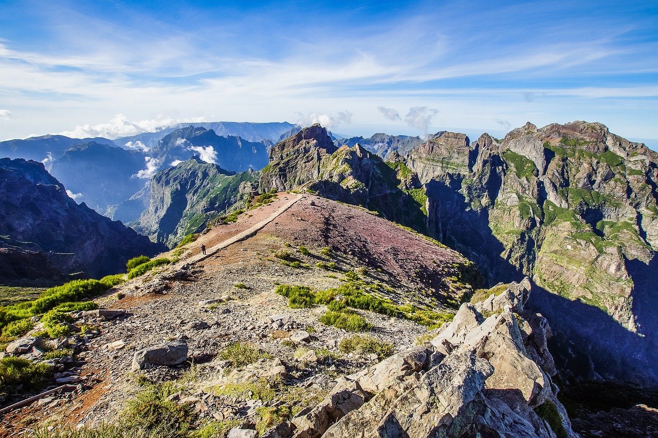 Vue panoramique des montagnes de Madère, avec des pentes escarpées recouvertes de végétation luxuriante sous un ciel dégagé