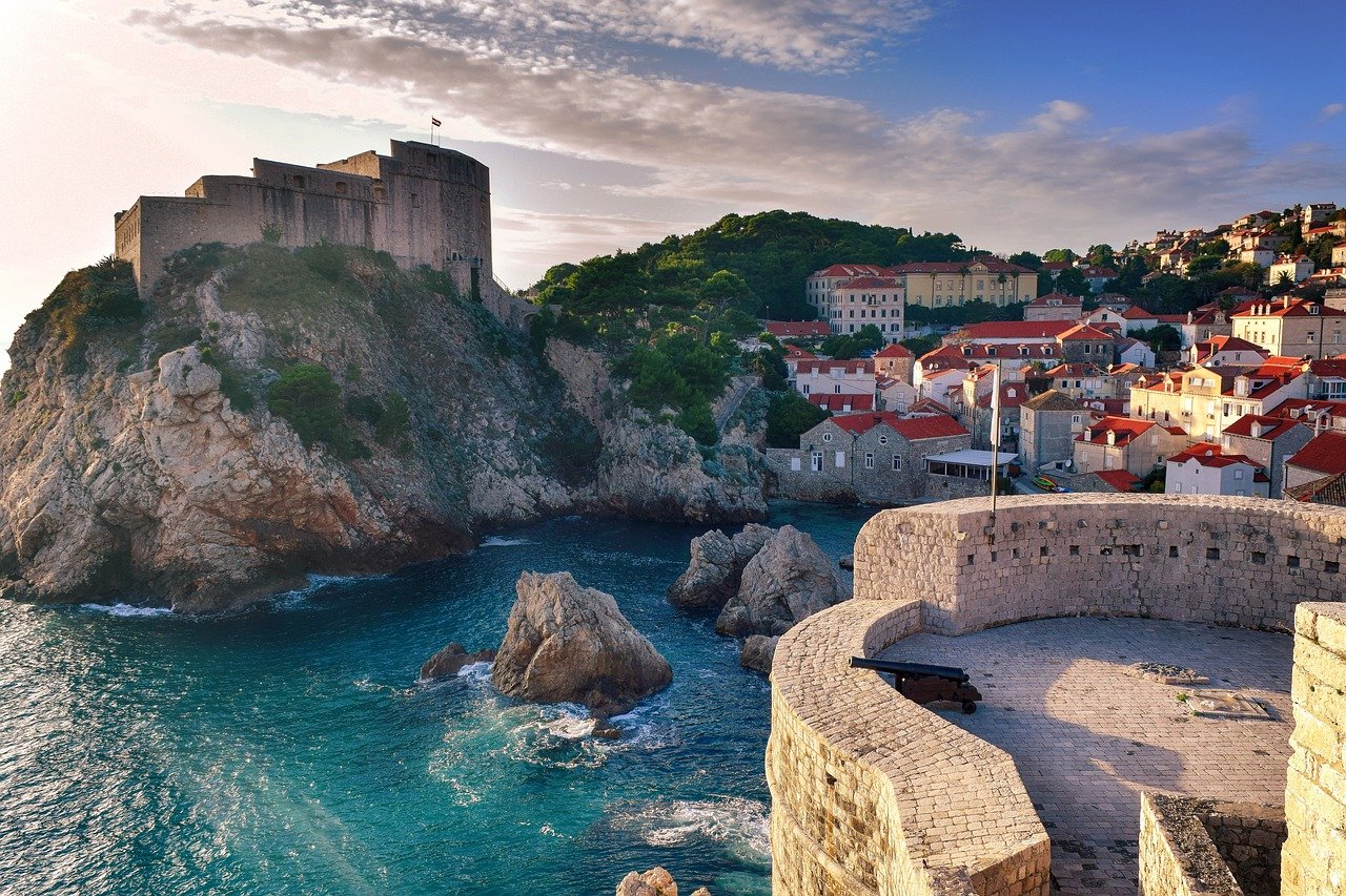 Vue depuis les remparts de Dubrovnik offrant un panorama spectaculaire sur la vieille ville avec ses toits de tuiles rouges, ses ruelles étroites, et la mer Adriatique scintillante