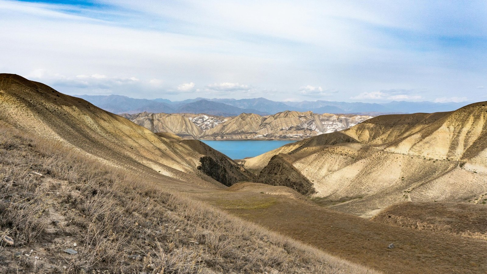 Magnifique paysage montagneux du Kirghizistan avec un lac aux eaux cristallines, entouré de sommets majestueux et de vallées verdoyantes