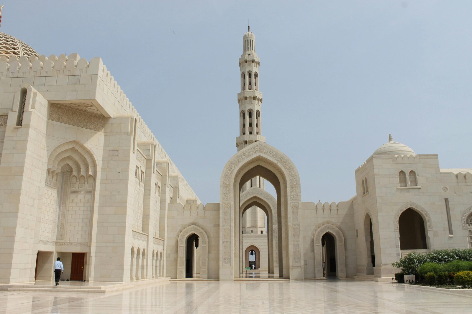 Vue impressionnante de la Grande Mosquée du Sultan Qabus à Oman, mettant en avant son architecture majestueuse, son dôme imposant et son minaret élégant