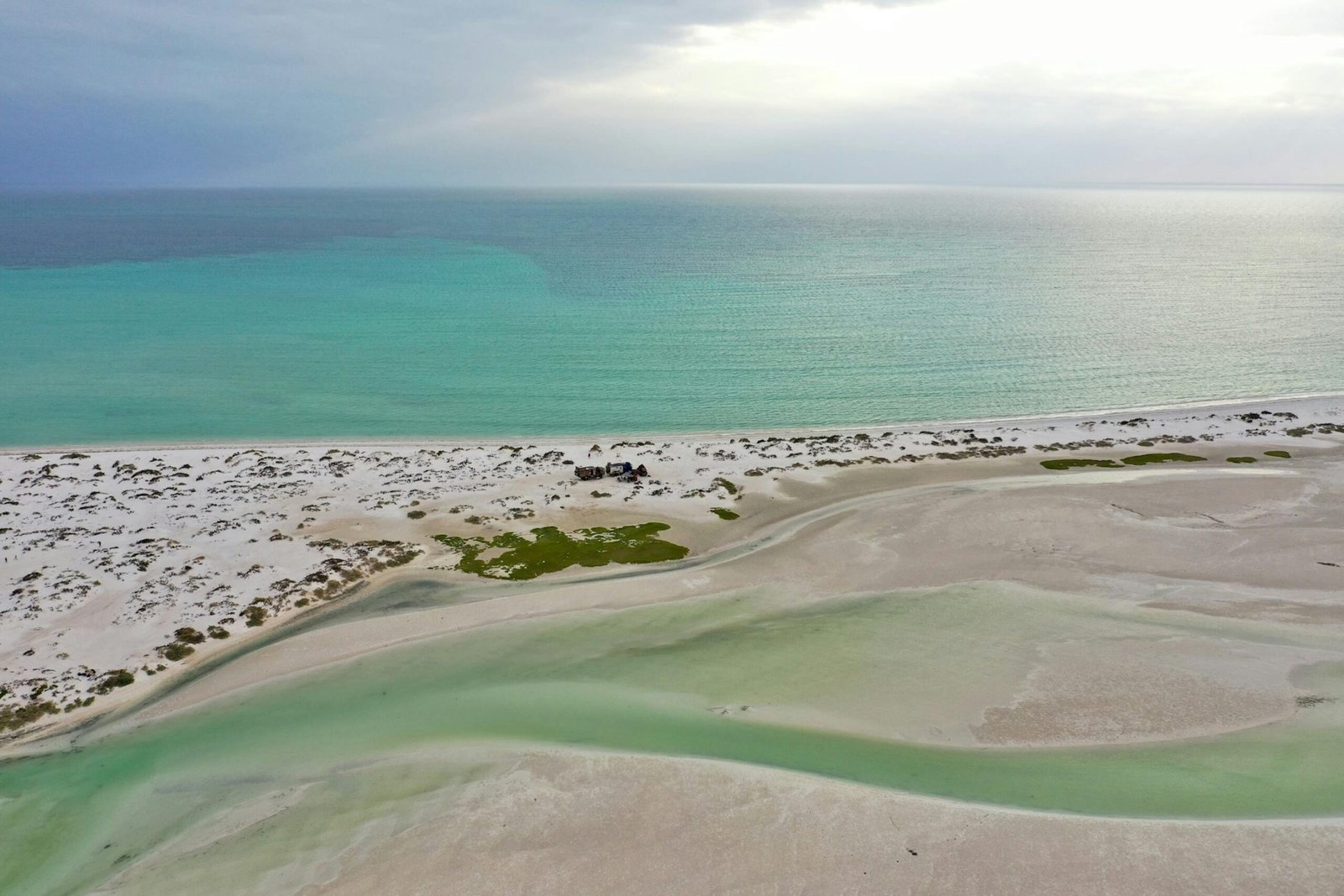 Superbes dunes de sable doré rencontrant les eaux scintillantes de la mer à Oman, offrant un paysage contrasté entre désert et océan