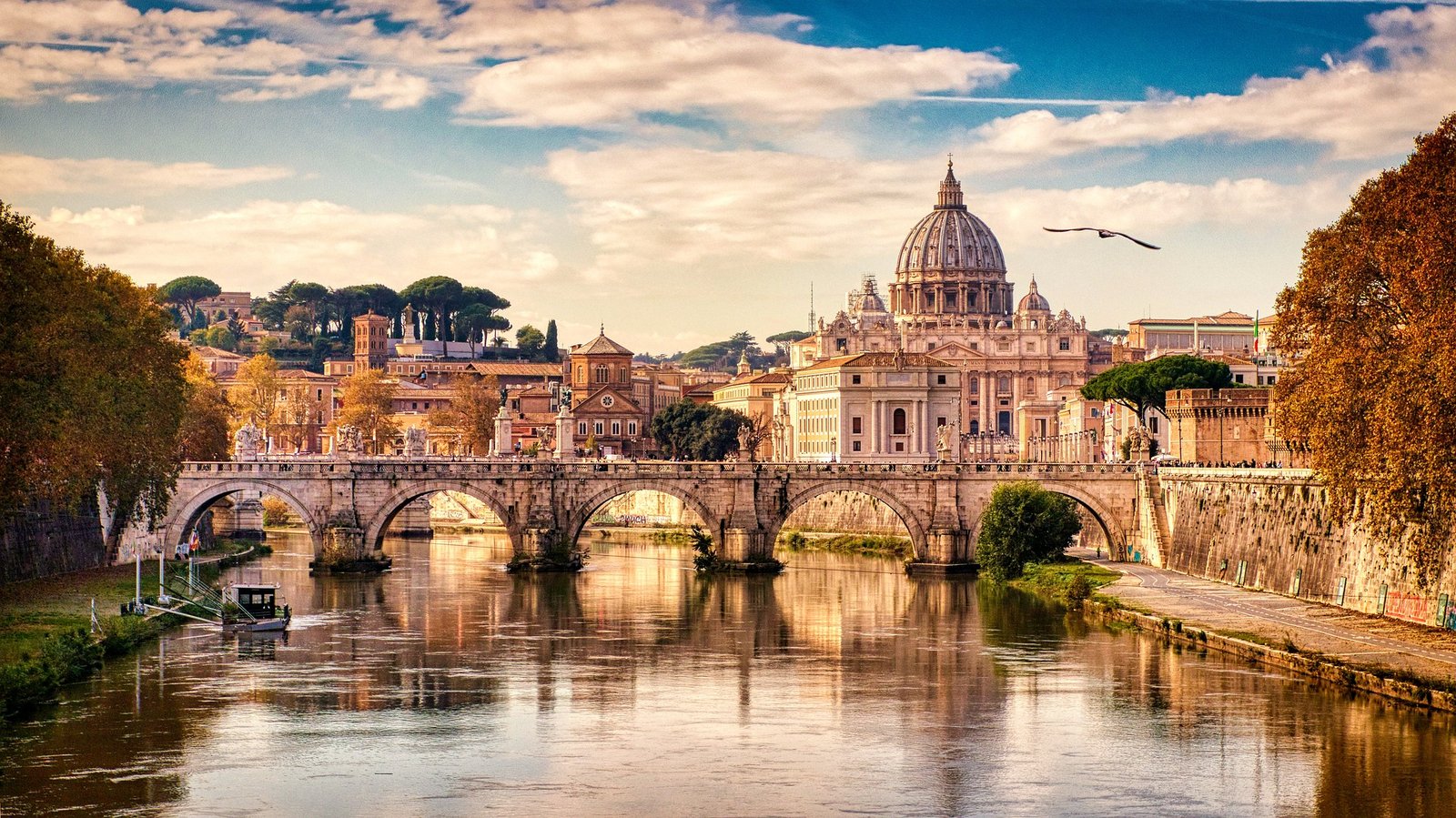 Vue sur le Pont Umberto I, élégant et majestueux, avec la Basilique Saint-Pierre en arrière-plan, se détachant à l’horizon dans une composition harmonieuse au-dessus du Tibre