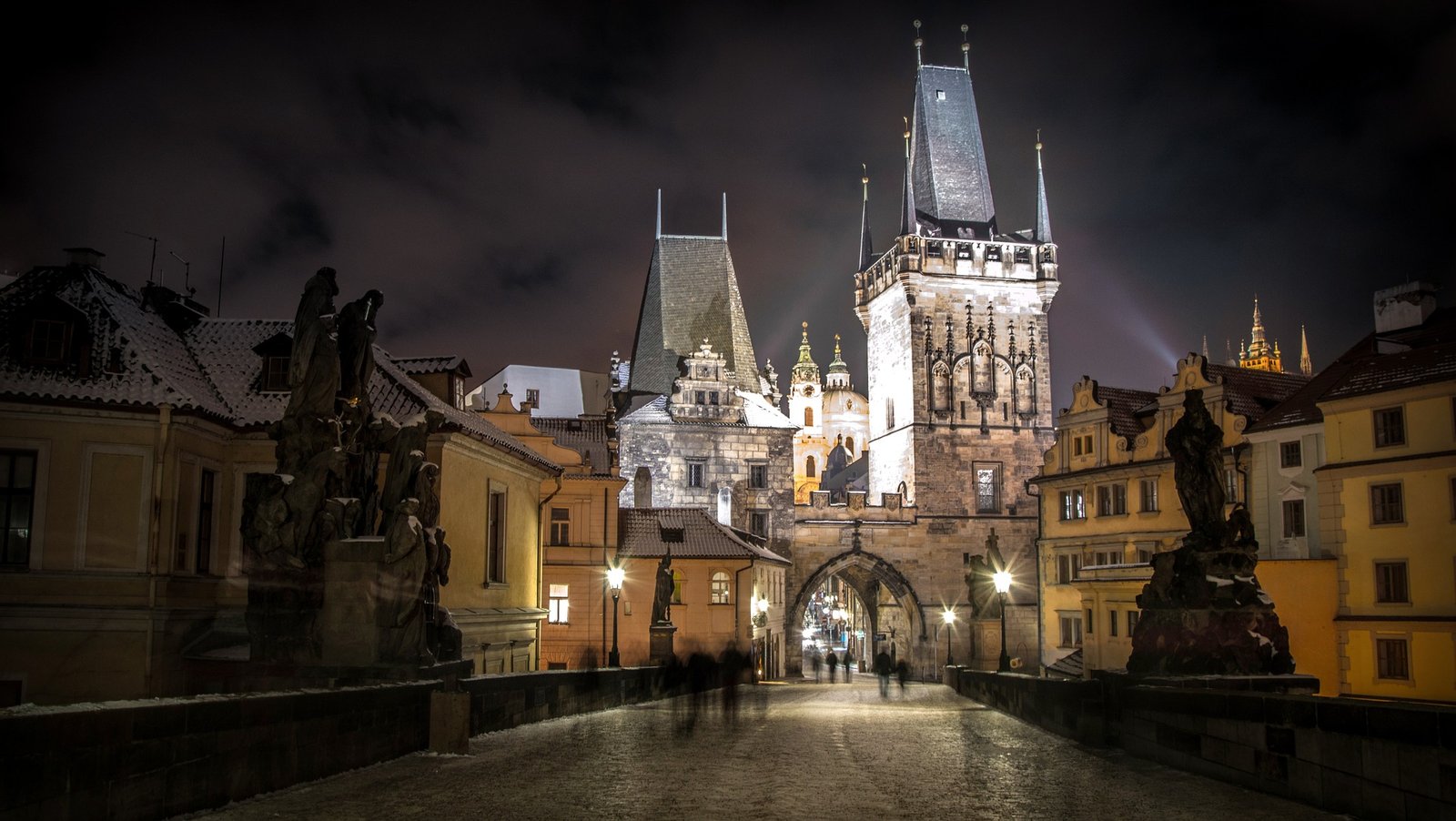 Vue nocturne de la vieille ville de Prague, mettant en valeur ses rues pavées et son architecture historique illuminée, créant une atmosphère romantique et intemporelle