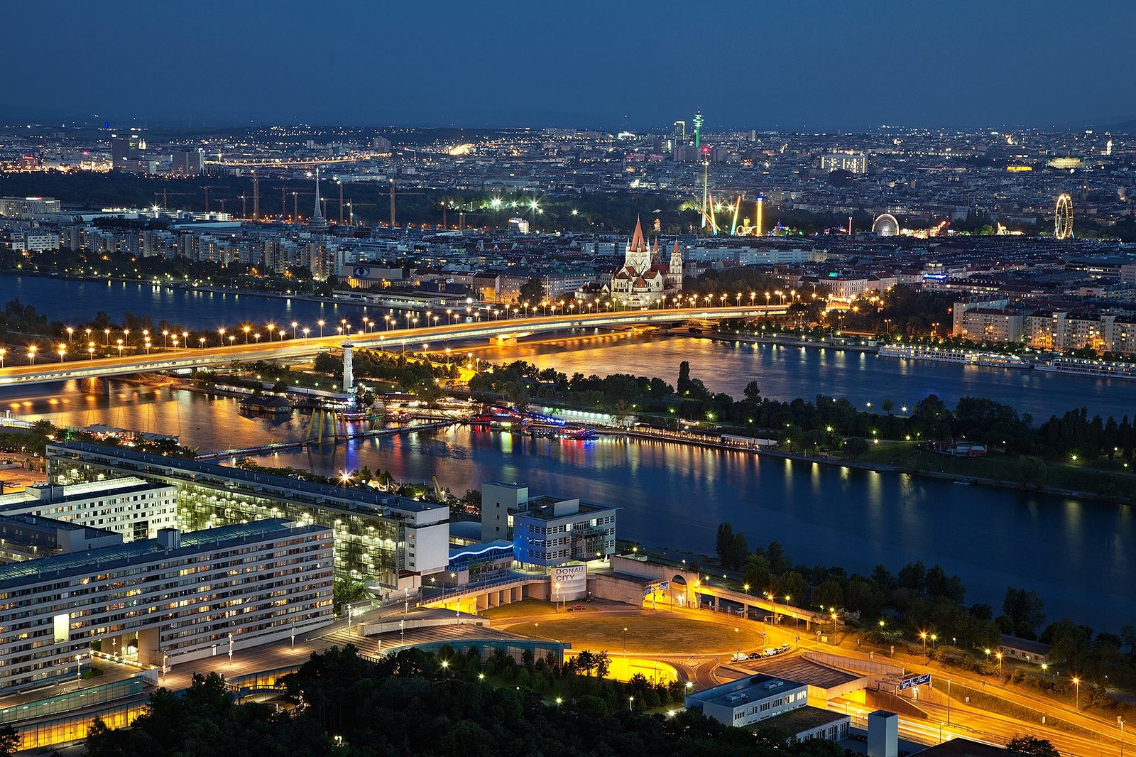 Vue panoramique sur la vieille ville de Vienne au coucher du soleil, mettant en valeur ses toits historiques, et l’architecture impériale autrichienne