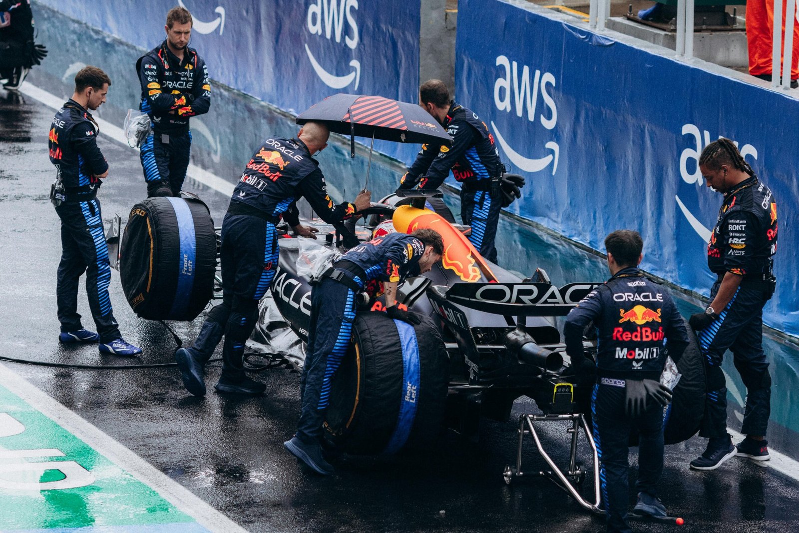Arrêt au stand lors d'une course de Formule 1, avec des mécaniciens en action changeant les pneus et ravitaillant la voiture à une vitesse fulgurante