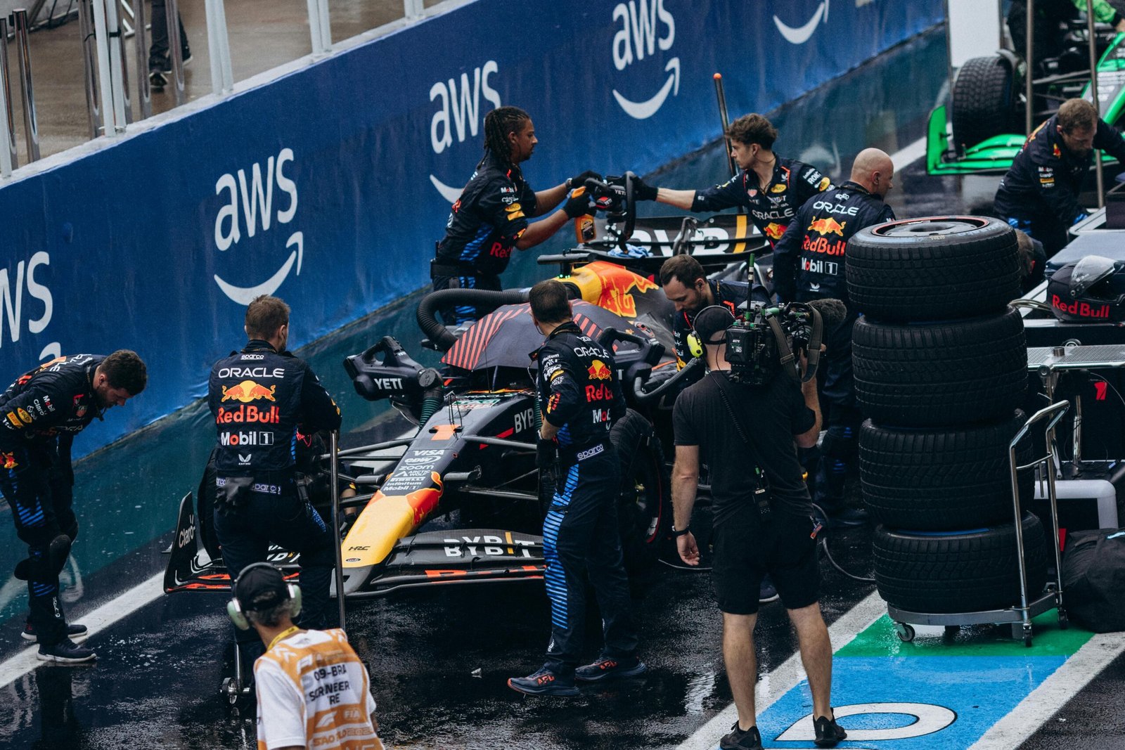 Arrêt au stand lors d'une course de Formule 1, avec des mécaniciens en action changeant les pneus et ravitaillant la voiture à une vitesse fulgurante