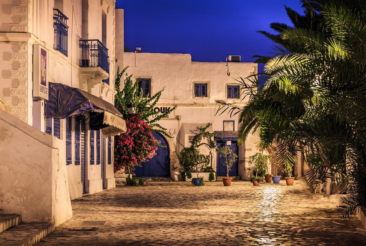 Vue nocturne de Houmt Souk à Djerba, avec ses ruelles animées, ses bâtiments blanchis à la chaux et ses éclairages chaleureux créant une ambiance méditerranéenne authentique