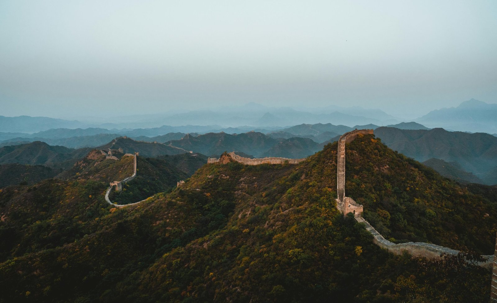 Grande Muraille de Chine Vue panoramique de la Grande Muraille de Chine, une des 7 merveilles du monde, serpentant à travers les montagnes verdoyantes sous un ciel clair
