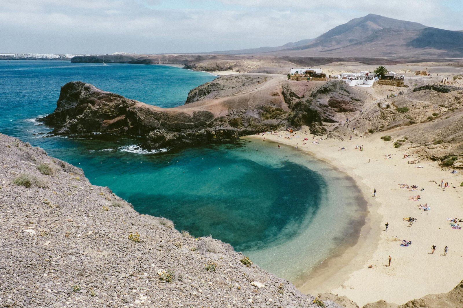 Vue sur l'océan Atlantique avec des montagnes volcaniques en arrière-plan à Lanzarote, créant un paysage spectaculaire sous un ciel clair