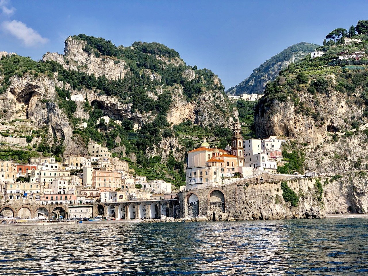 Village d'Amalfi avec ses maisons pastel en bord de mer, niché entre falaises et Méditerranée