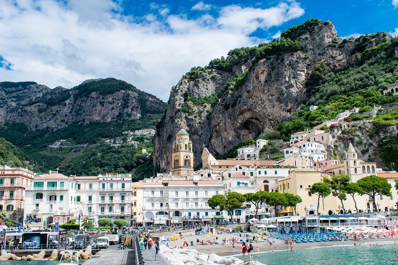 Village d'Amalfi avec ses maisons pastel en bord de mer, niché entre falaises et Méditerranée