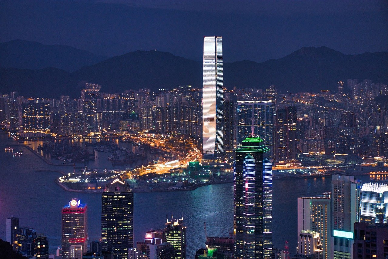 Skyline de Hong Kong illuminée la nuit avec reflets sur la baie Victoria