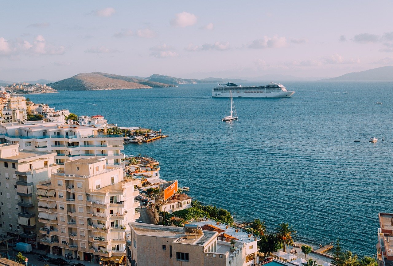 Côte albanaise avec la mer Adriatique s'étendant à perte de vue, ponctuée de bateaux de croisière naviguant paisiblement au large