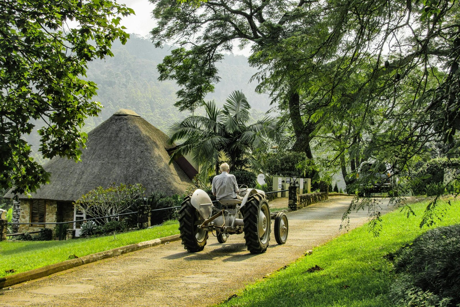 Paysan conduisant un tracteur à Eswatini, au milieu d'un paysage rural verdoyant et vallonné