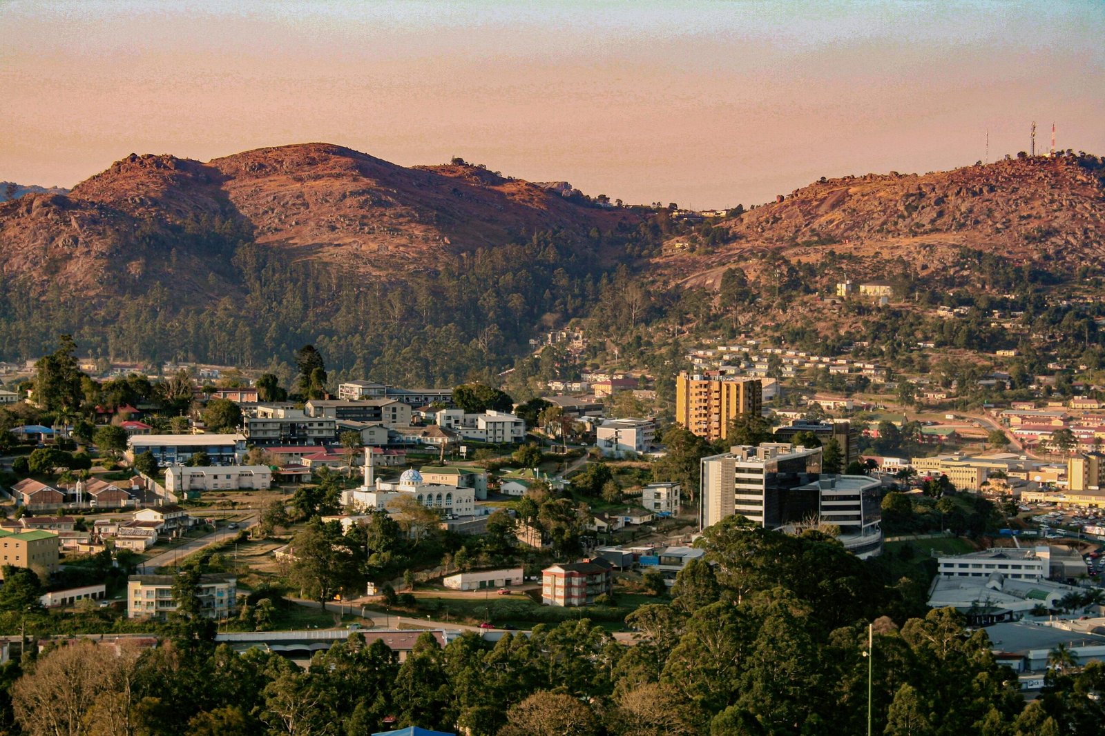 Vue sur un village traditionnel en Eswatini, entouré de collines verdoyantes et de huttes en chaume