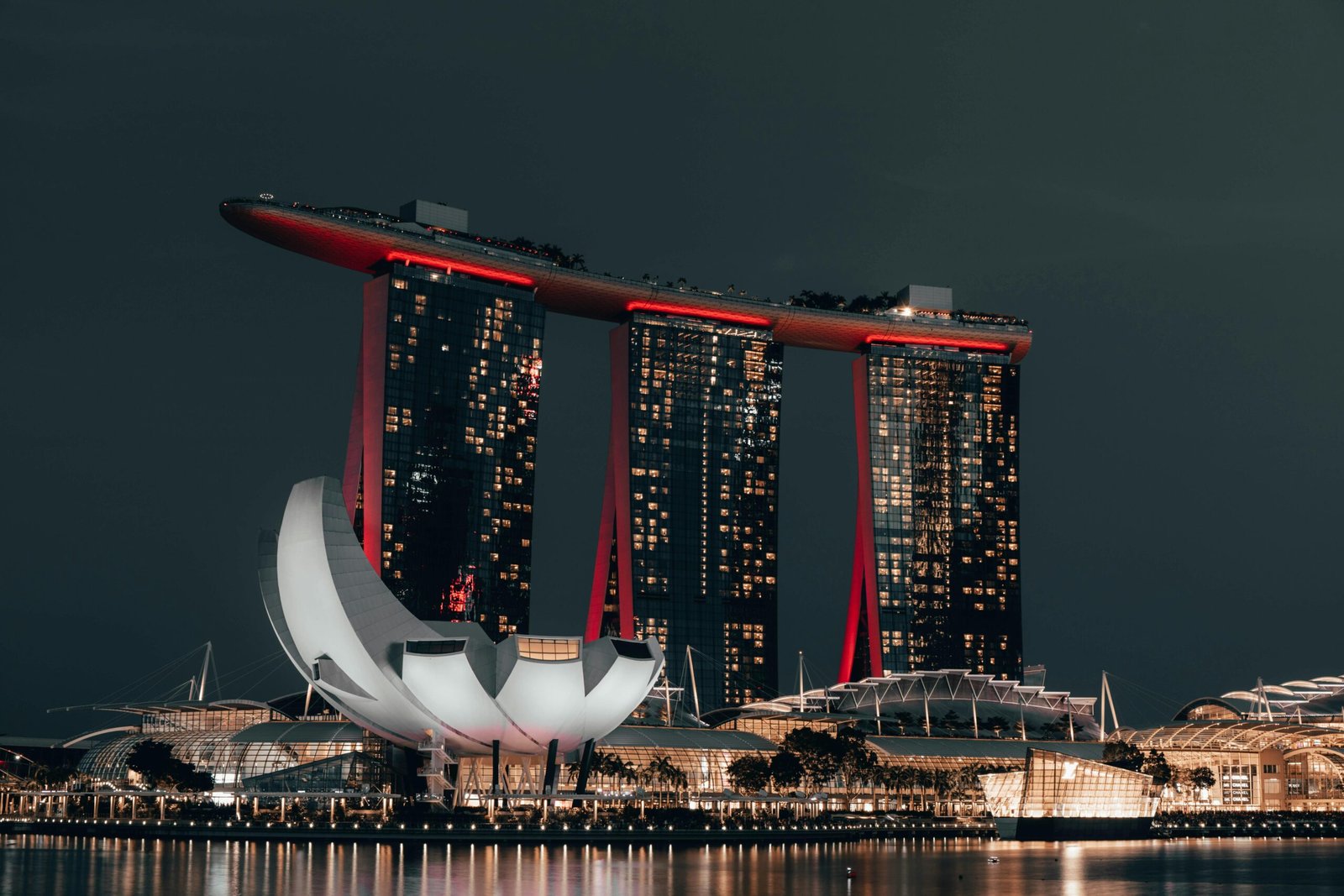 Vue emblématique sur le Marina Bay Sands à Singapour, avec ses trois tours surmontées de la SkyPark, éclairées la nuit en bord de baie