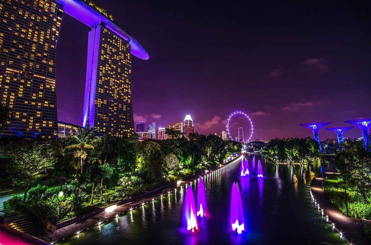 Vue panoramique de Singapour de nuit avec le Marina Bay Sands, les Jardins de la Baie illuminés et les gratte-ciels scintillants en arrière-plan