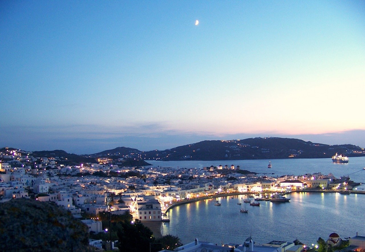 Vue panoramique sur Mykonos le soir, ville éclairée avec l’océan en arrière-plan dans les Cyclades en Grèce